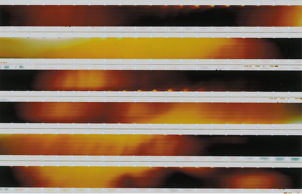 Strips of 16mm laid horizontally to show red and yellow flares of light