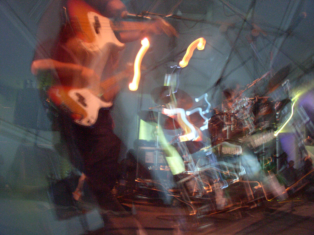 A blurry long exposure of a guitarist playing on stage