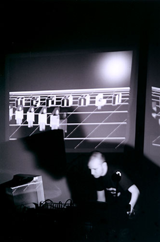 A B and w image of a man looking at a computer as digital graphics are projected