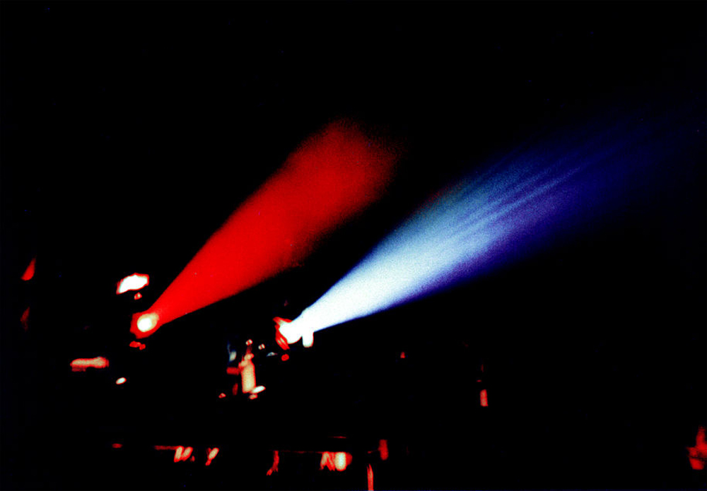 Two shafts of light, one red, one blue come from two 16mm projectors 