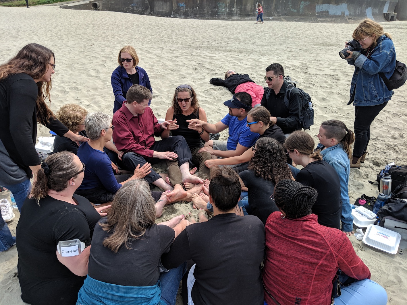 John Lee Clark sits on the beach with a big group of people, all touching