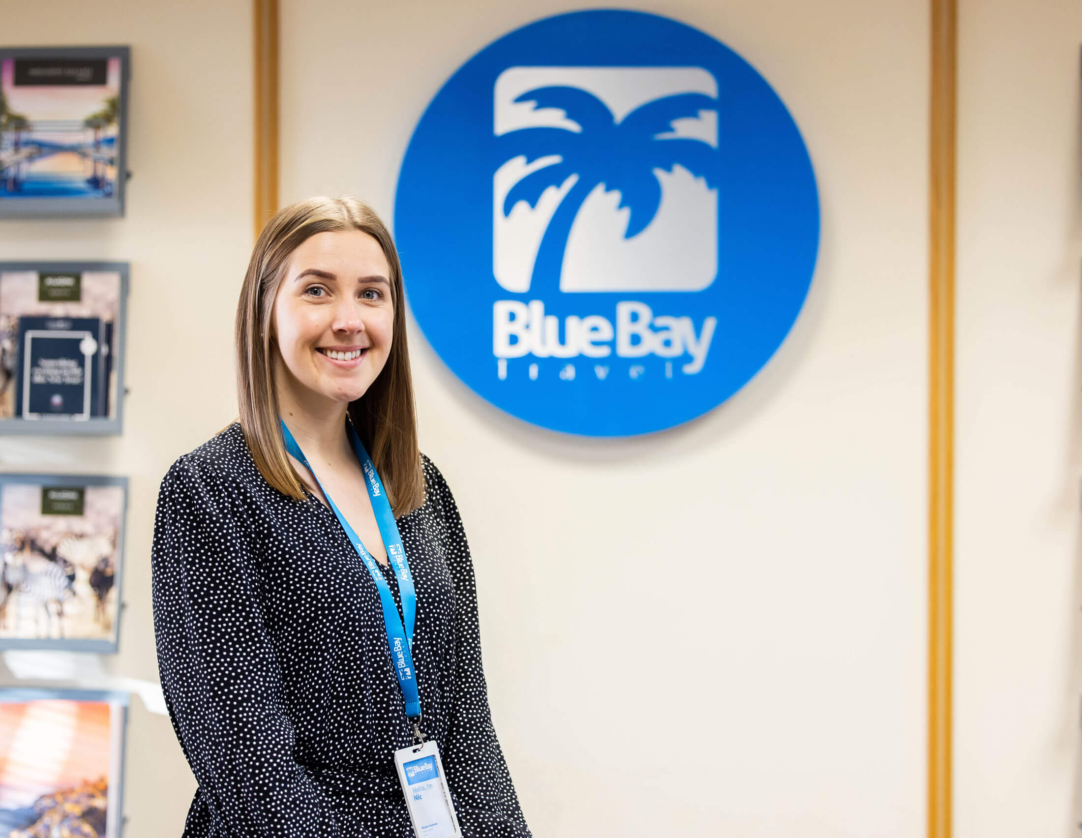 The Head of Sales in front of the Blue Bay Travel logo