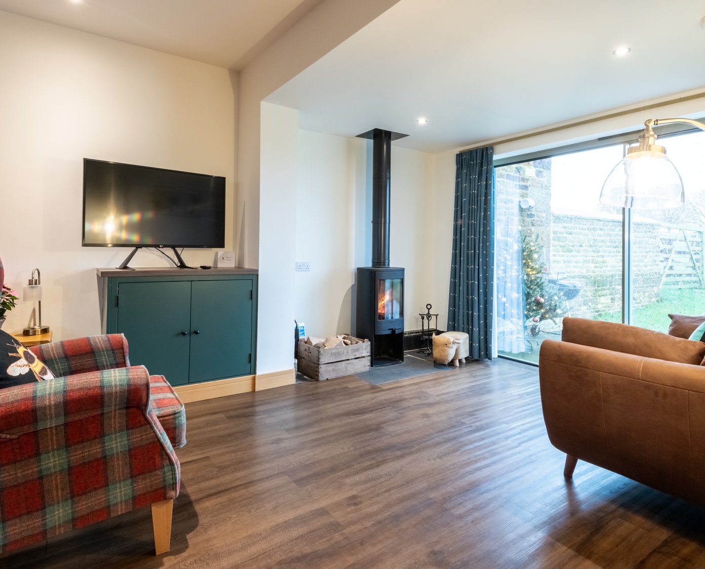 Log burner, smart TV, tartan chair and leather sofas in the cosy living area with lovely views over parkland.