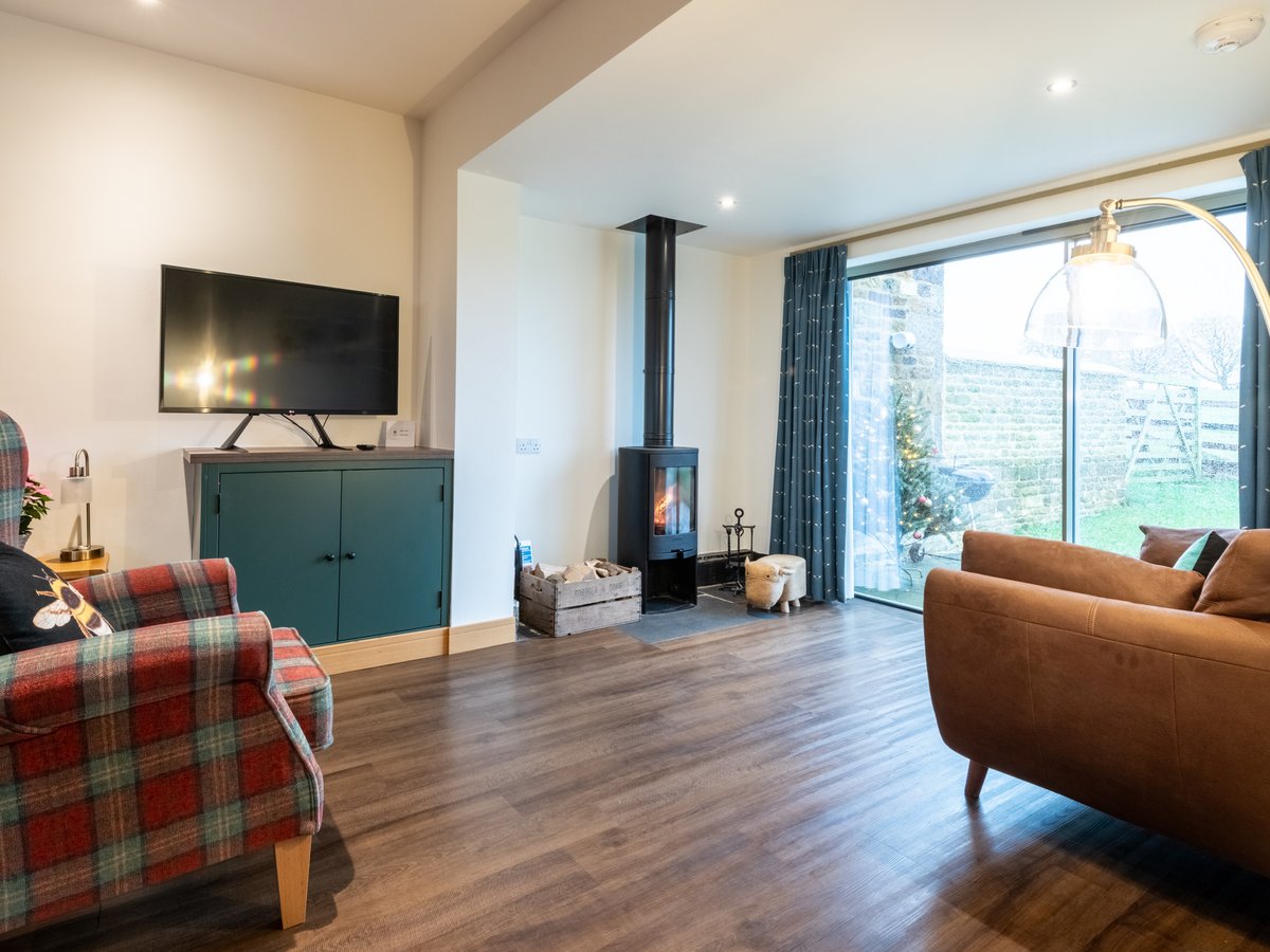 Log burner, smart TV, tartan chair and leather sofas in the cosy living area with lovely views over parkland.