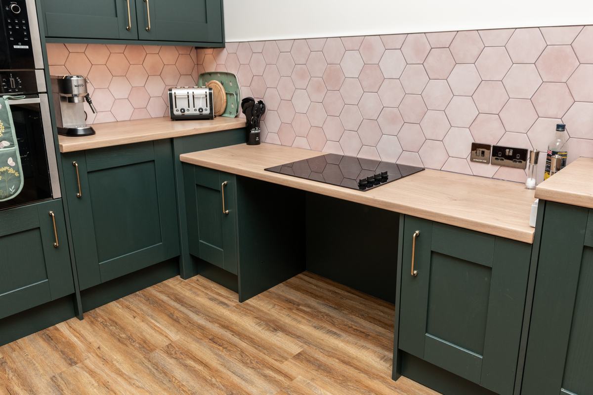 close up of roll under hob, with an espresso machine and dualit toaster and neff microwave above a neff hide and slide fan oven
