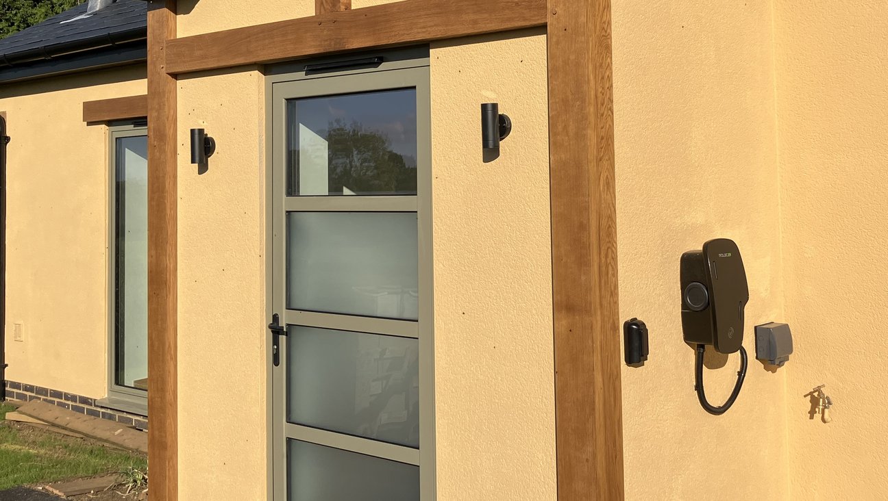 

                                        golden rendered cottage with oak porch and car charger, outside tap and socket to right of door