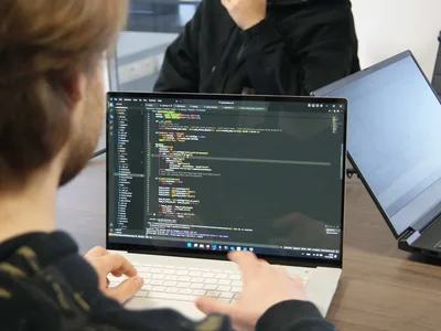 Een developer werkt aan code op een laptop, met een badeendje ernaast