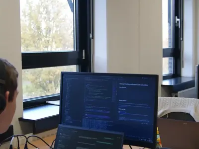 Een laptop met code op een bureau bij het raam