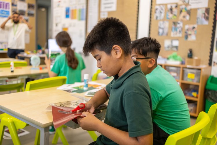 Children doing a classroom craft activity with a teacher, photographed from the side at Olga Primary School