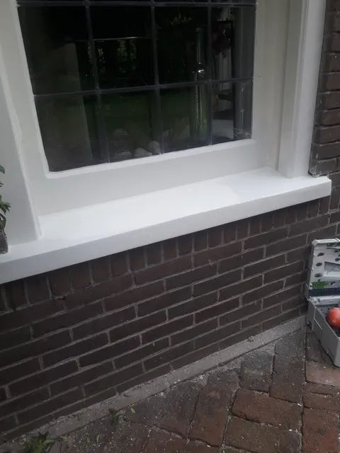 Een hersteld en geschilderd raamkozijn na houtrotherstel
