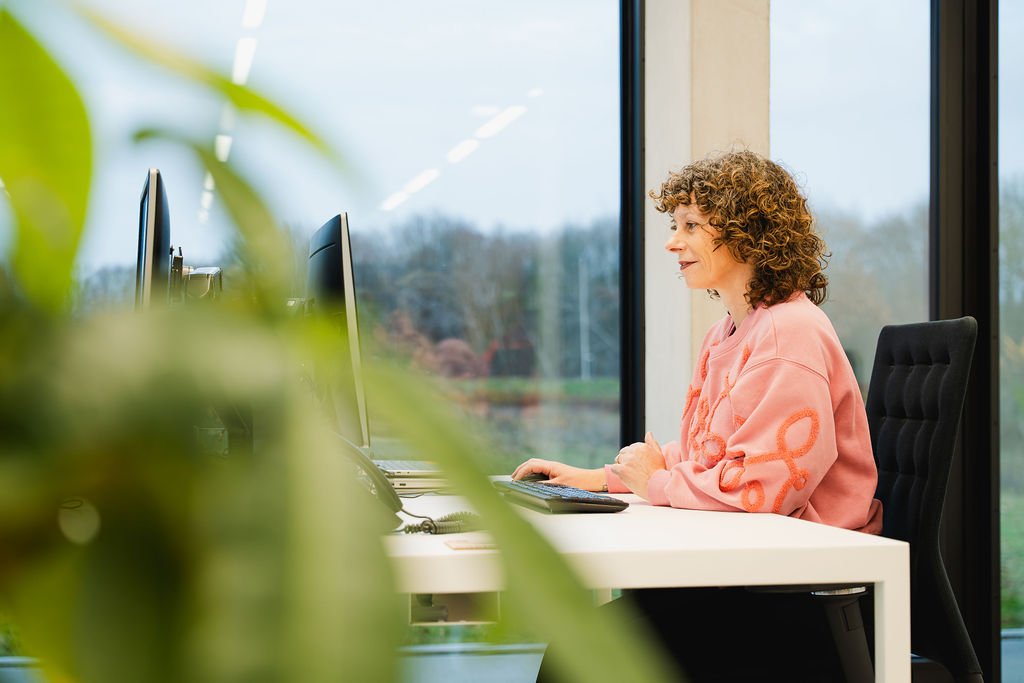 Collega werkt aan bureau op de laptop