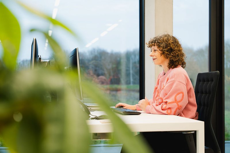 Collega werkt aan bureau op de laptop