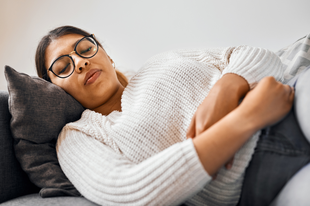 Women laying on the sofa holding her stomach