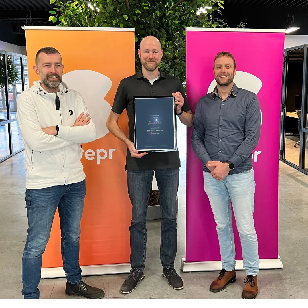 Drie Skrepr-collega's poseren trots met een ingelijst P3 Express certificaat voor de Skrepr-banners