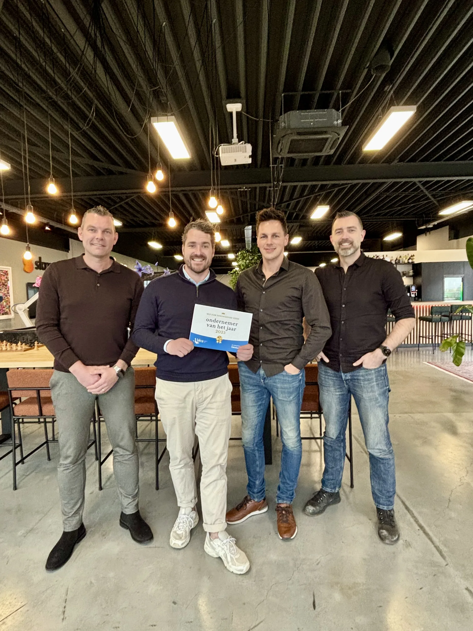 Vier Skrepr-collega's poseren trots met de award voor ondernemer van het jaar 2025