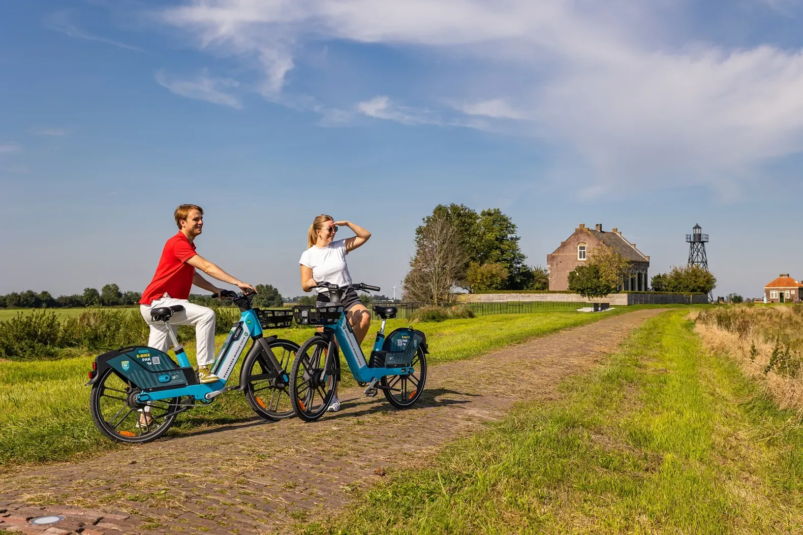 Twee bezoekers met deelfietsen op het voormalige eiland Schokland in Flevoland
