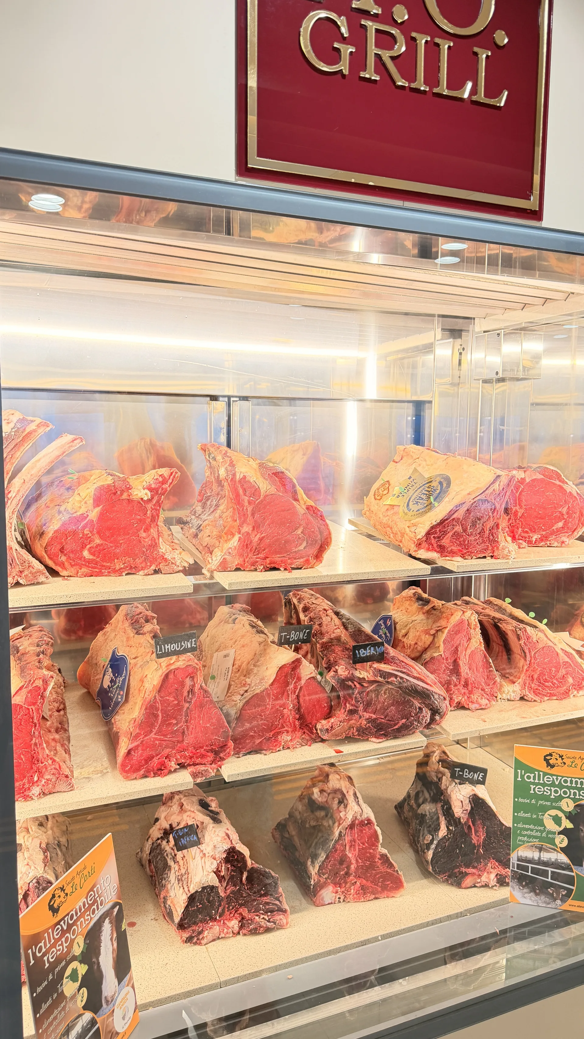Vleesvitrine met dry-aged cuts, gelabeld met Limousine, T-Bone en Iberico, bij een grill-slagerij