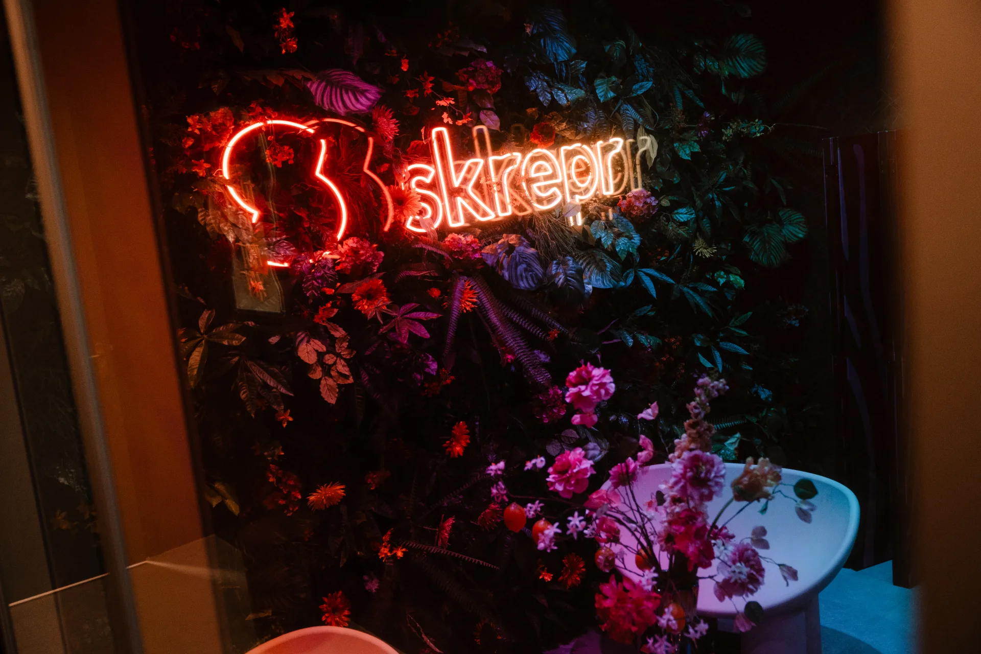 Skrepr-kantoor op Urk met neon-signage en bloemeninstallatie, teamleden aan het werk