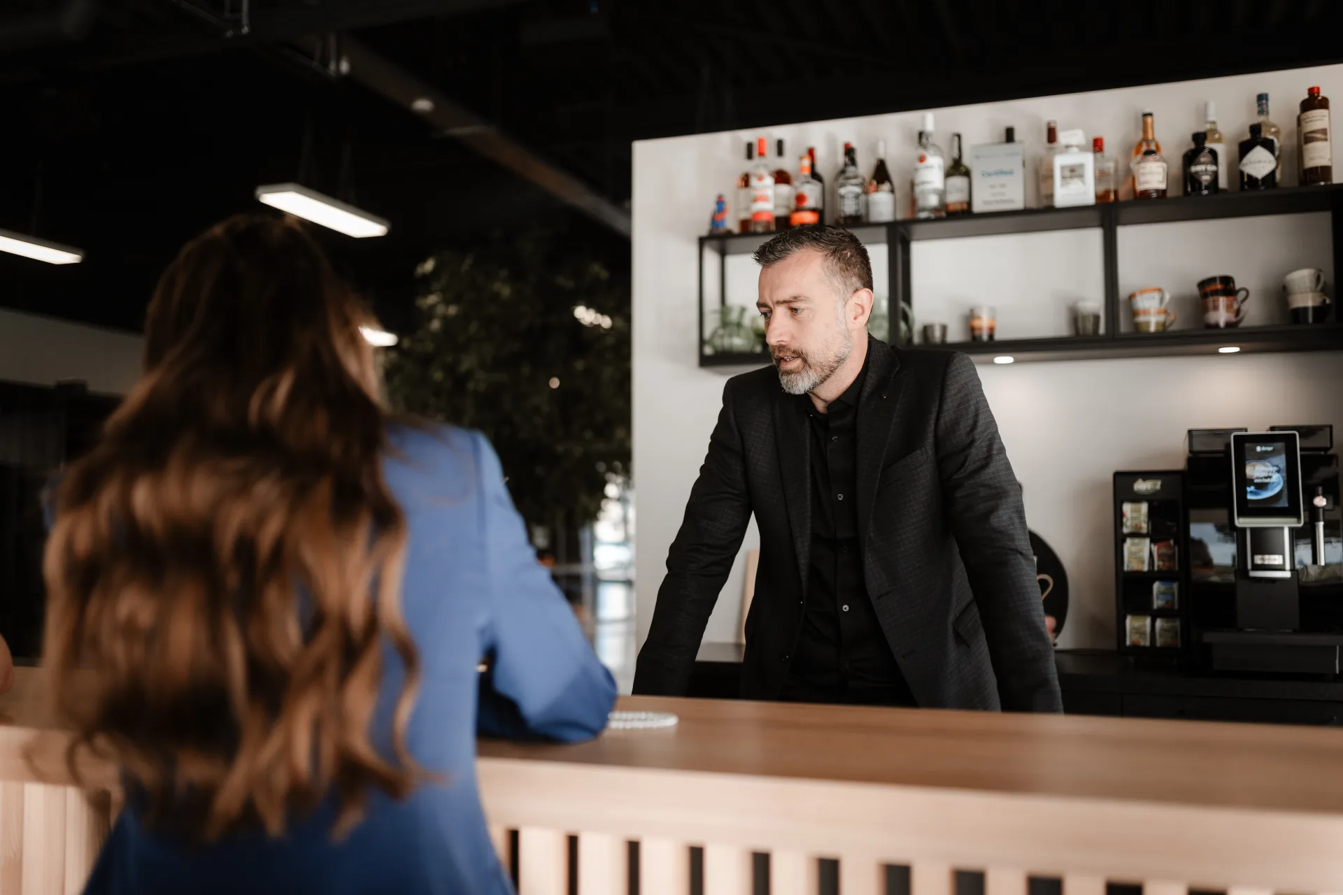 Skrepr-collega in gesprek met een klant aan de bar op kantoor op Urk