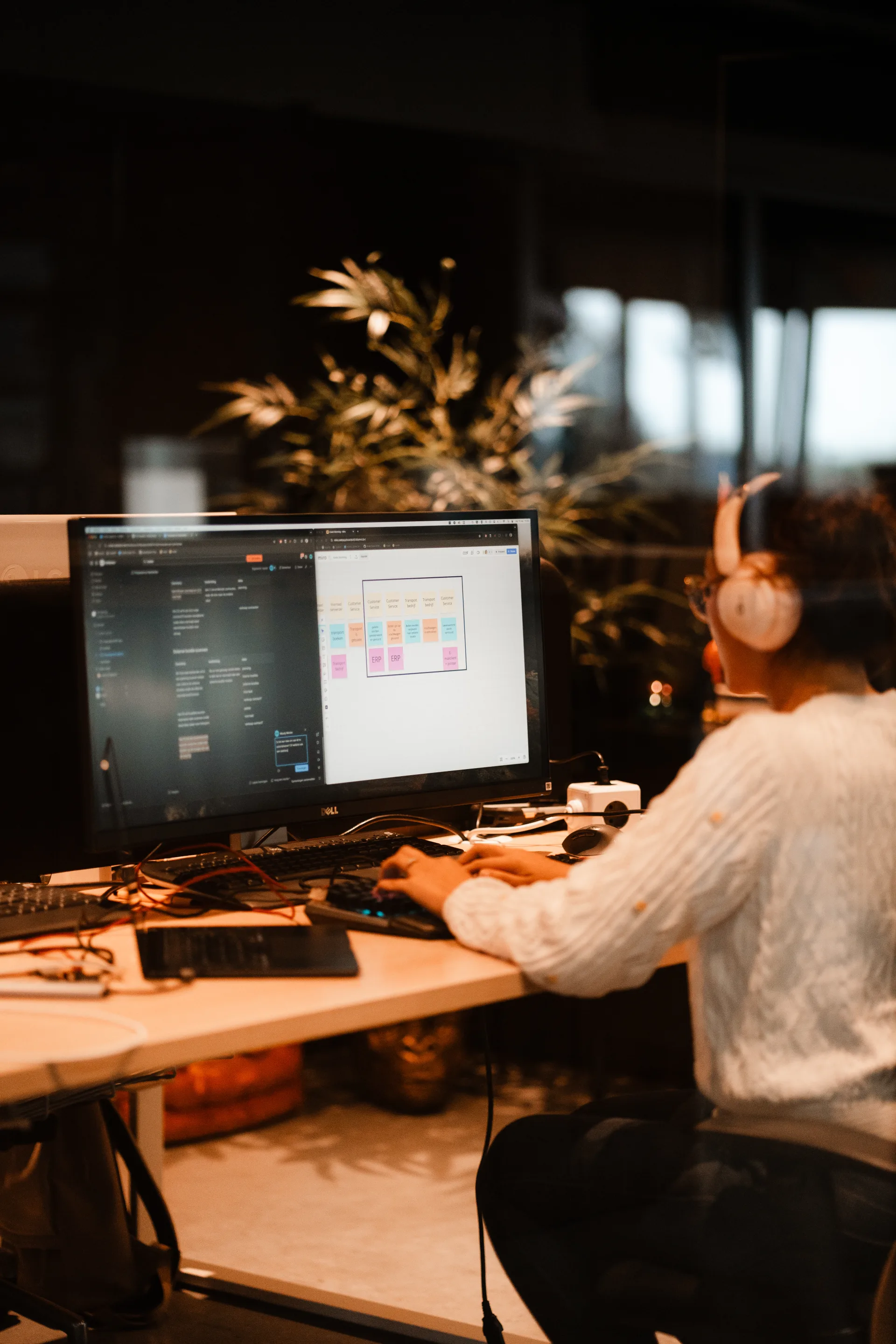 Developer werkt aan live dashboard met productie-inzichten terwijl collega meekijkt