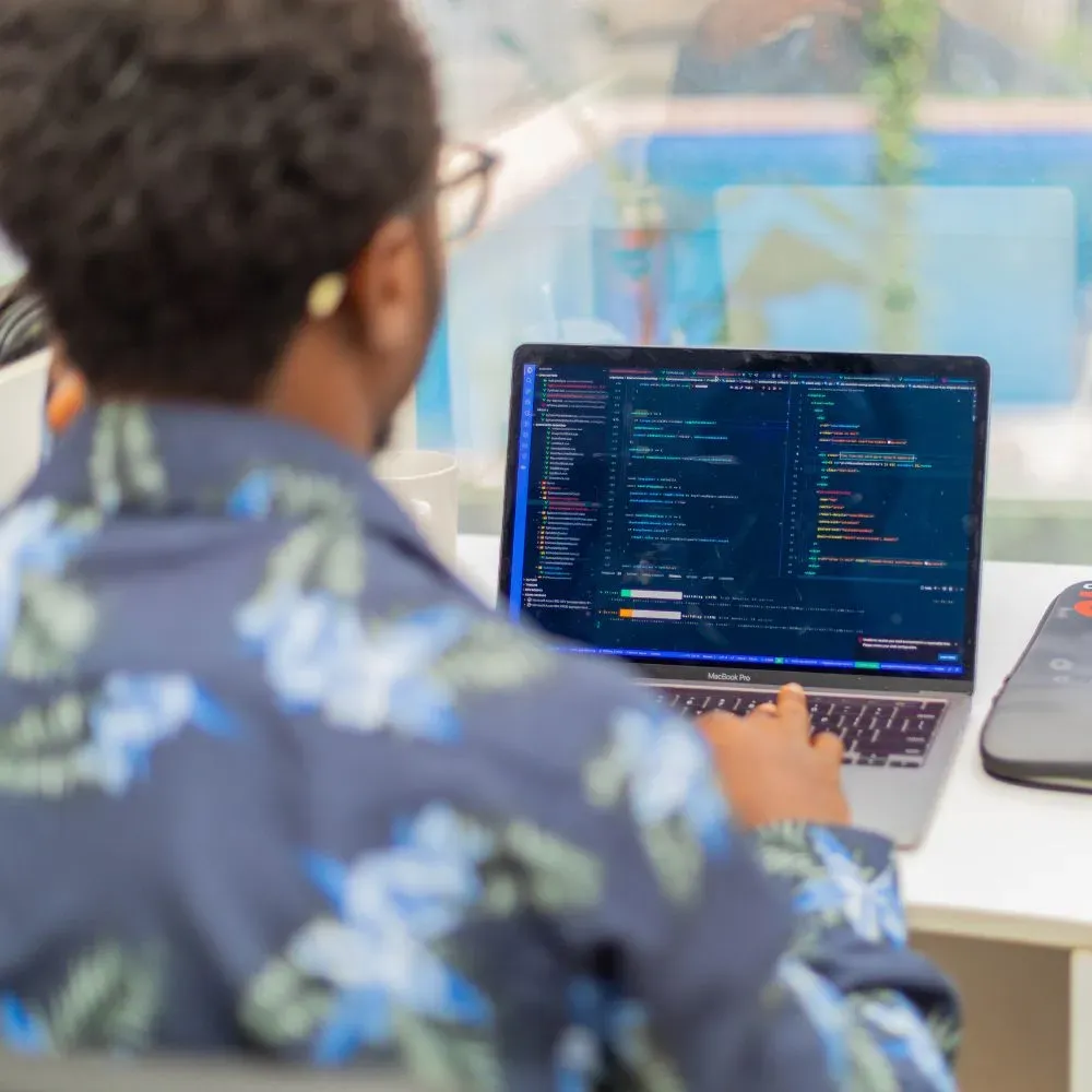 A developer writing code on a laptop