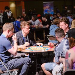 People playing in a CATAN tournament at a round table