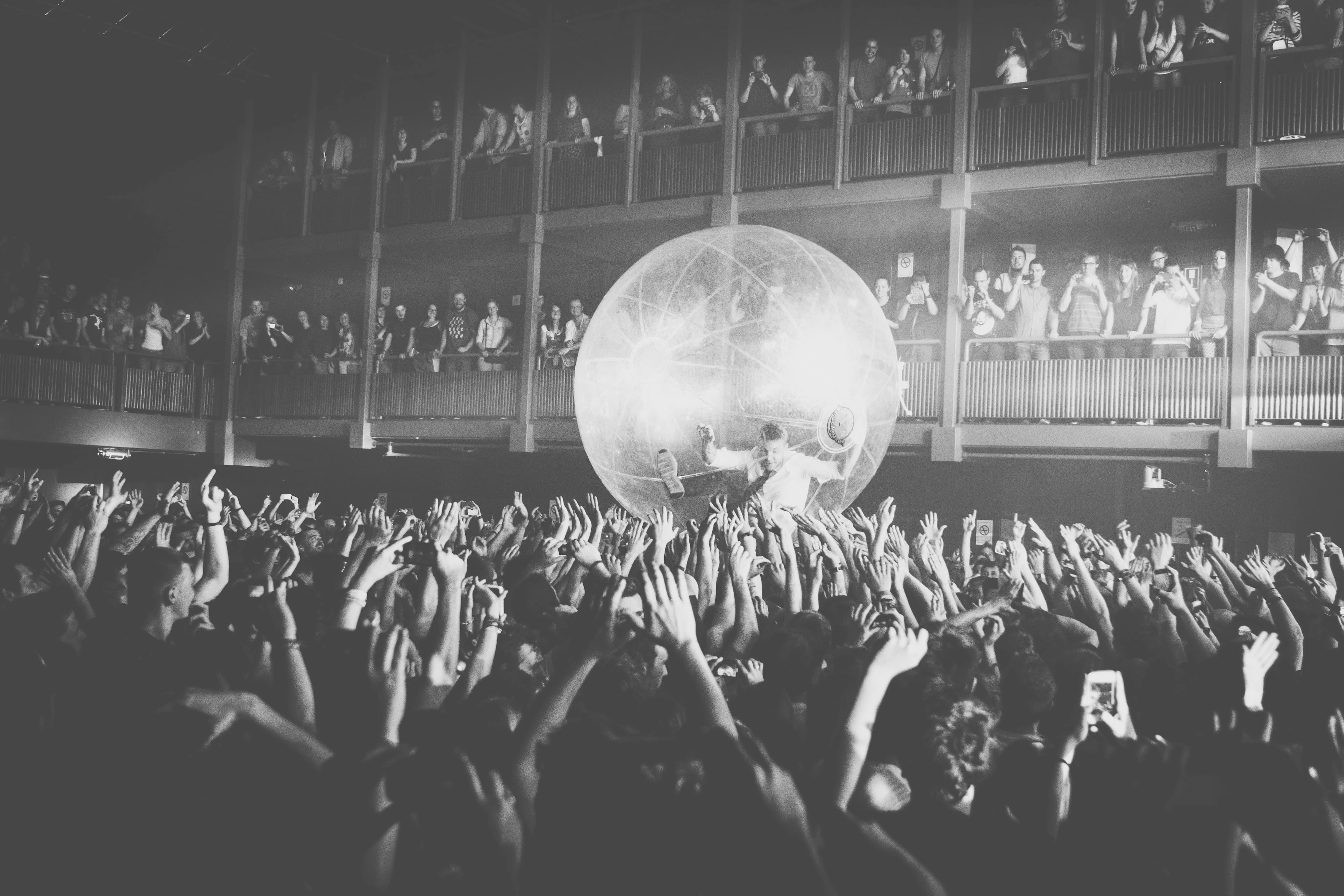 Black and white photo of a concert crowd with hands up
