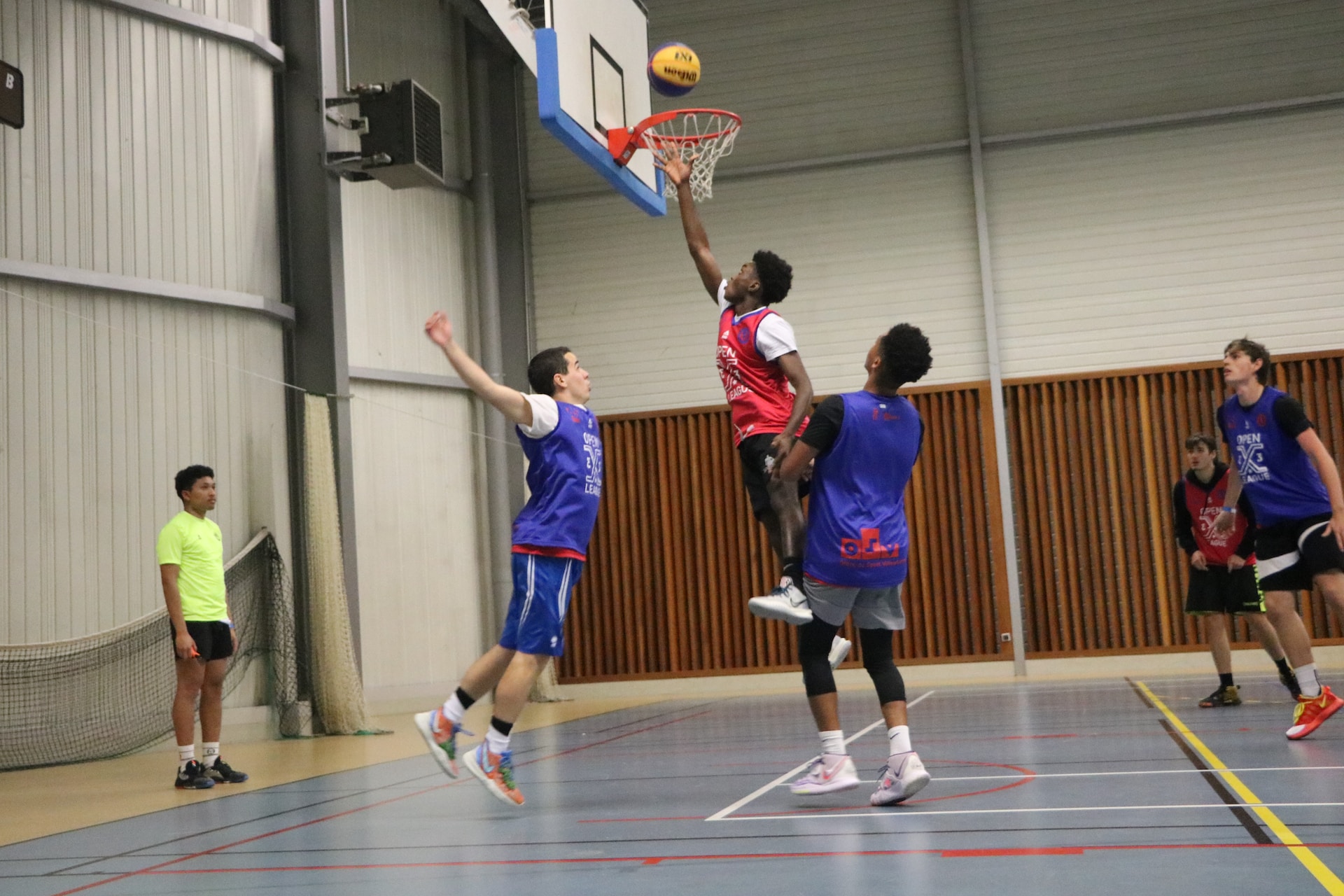 A group of young men playing a game of basketball by Ludo Poiré